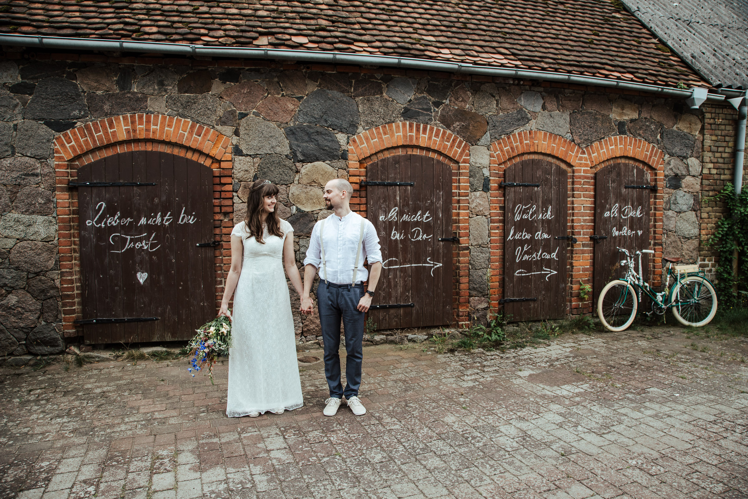 das Brautpaar vor der Scheunen Hand in Hand vor ihrer Scheunenhochzeit